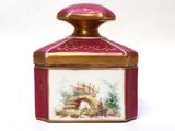 a pink and gold box with a painting on it