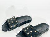 une paire de sandales noires ornées de clous dorés