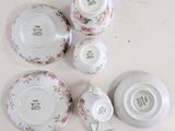 a lot of white plates and cups on the table