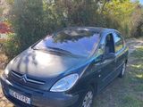 La voiture est garée sur le bord de la route, dans l'herbe.