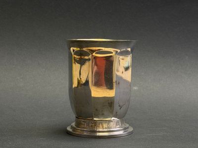 a silver vase that is sitting on a table