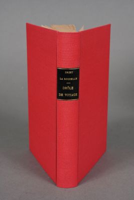 a red book sitting on top of a table next to a gray wall