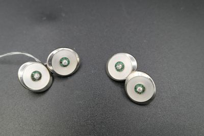 deux boutons de manchette en argent ornés de pierres vertes et blanches