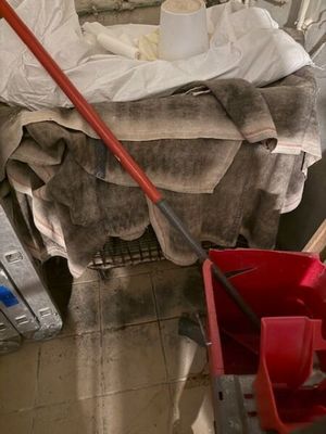 une serpillière posée par terre à côté d'une pile de vêtements