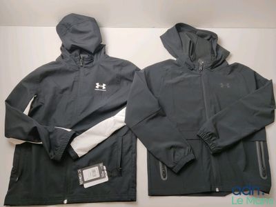 two men ' s under armour jackets with hoods on top of them