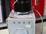 a black coffee pot sitting on top of a box