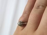 a woman ' s hand with a ring on it ' s finger