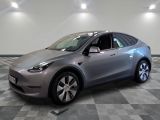 une photo d'une Tesla Model Y argentée posée sur un sol à damier