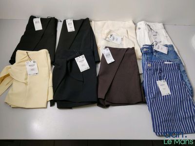 several men ' s shirts and pants are lined up on a table