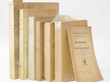 several books are stacked on top of each other on a white surface