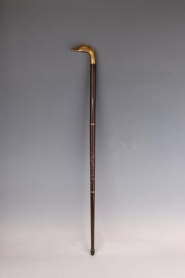 an old cane with a wooden handle sitting on a white surface