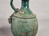 an old green vase with a handle on a white background
