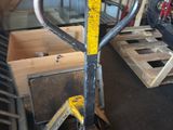 une fourche posée sur une palette dans un garage