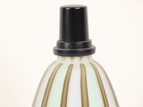 a close up of a white and gold vase with a black top