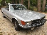 a silver car parked in a gravel parking lot