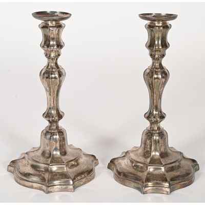 pair of antique silver candlesticks on stands on a white background