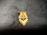 a gold plated metal object on a black surface