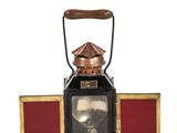 a black and gold lantern with a red cover