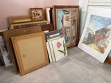 a lot of framed and unframed art on the floor