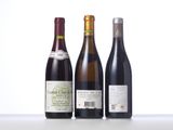three bottles of wine are lined up on a table