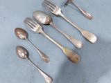 cinq cuillères en argent et deux cuillères en argent sur une table