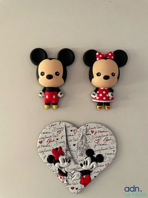 mickey and minnie mouse figurines on a white surface with a heart