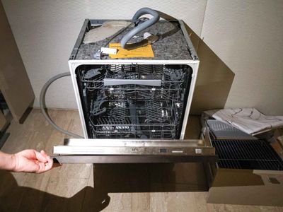 a person opening a dishwasher in a kitchen