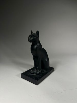 une image représentant une statue de chat assis sur un socle