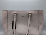a white purse with a black handle on a grey background