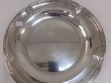 une assiette en argent posée sur une surface blanche