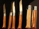 several knives are lined up in a row on a black surface