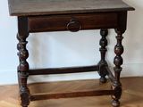 a small table with a drawer on it on a hard wood floor