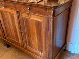 a wooden cabinet with a vase on top of it