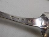 a silver spoon with a handle on a white surface