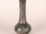 a green vase that is sitting on a white surface
