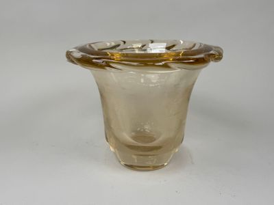 a glass vase with a gold rim sitting on a white surface
