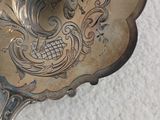 une cuillère en argent ornée d'un motif sur un fond blanc
