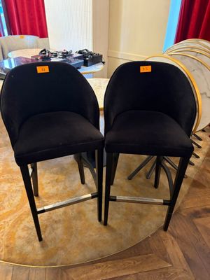 two black chairs sitting on top of a wooden floor next to a table