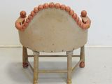 a small chair with beads on the back of it