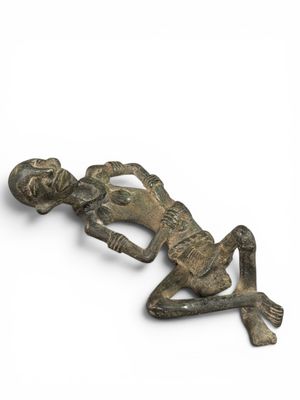 une figurine en bronze représentant un homme allongé sur le sol