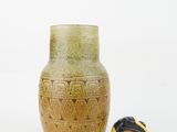 a vase and a tape measure on a white surface