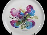 a white plate with a painting of a flower on it