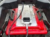 a red lawn mower that is sitting on the ground