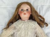 a doll that is laying down on a white sheet