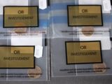 three clear bags with gold and black labels on them sitting on a table