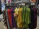 a lot of shirts hanging on a rack in a store