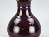 a purple vase with a gold rim sitting on a white surface