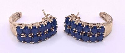two pairs of blue stone earrings on a white surface