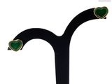 a close up of a pair of green earrings on a black stand