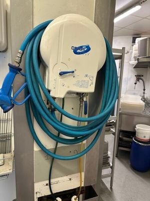 un tuyau bleu fixé au mur d'une cuisine